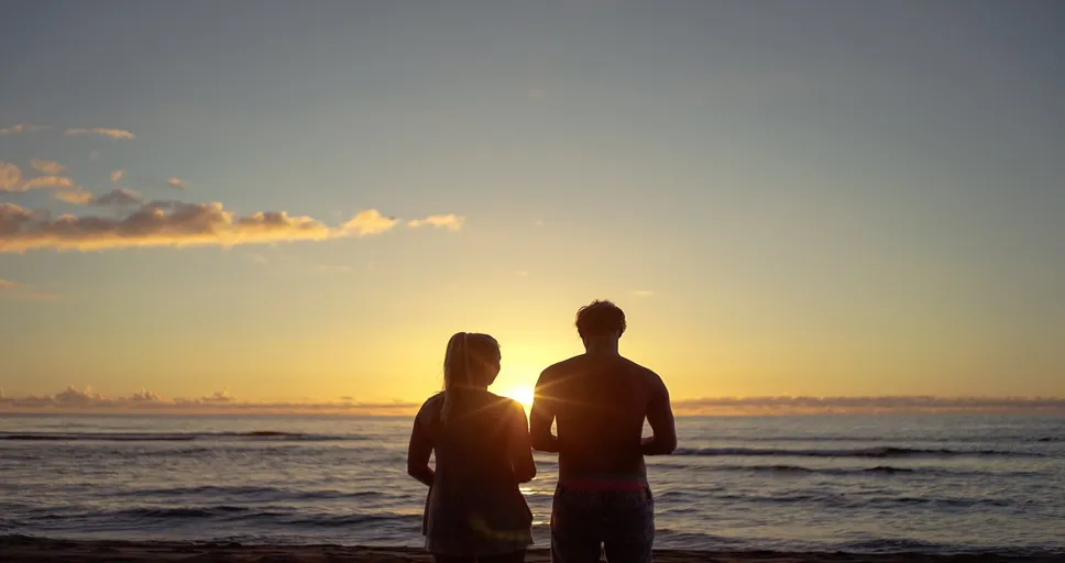 signs he wants you badly - couple, sunset, beach